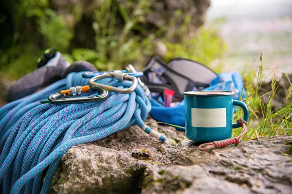 Equipo usado para escalar donde los mosquetones de cuerda y zapatillas de escalada junto a la taza en la que un plato vacío — Foto de Stock