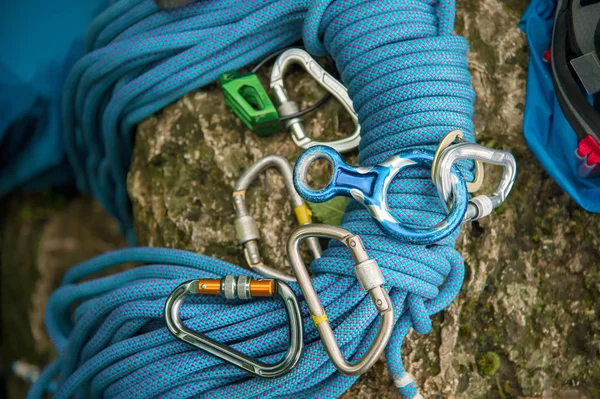 Used equipment for climbing where the rope carbines and climbing slippers lie on a rock — Stock Photo, Image