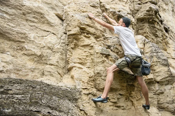 Ein junger Mann klettert ohne Versicherung auf einen steilen Felsen — Stockfoto