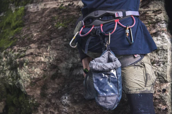 Primo piano di un arrampicatore di coscia con attrezzature su una cintura, sta su una roccia — Foto Stock