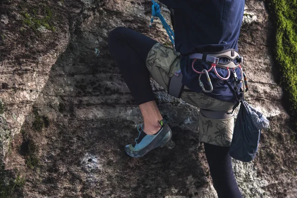 El primer plano de un escalador de muslos con el equipo en un cinturón, se encuentra en una roca — Foto de Stock