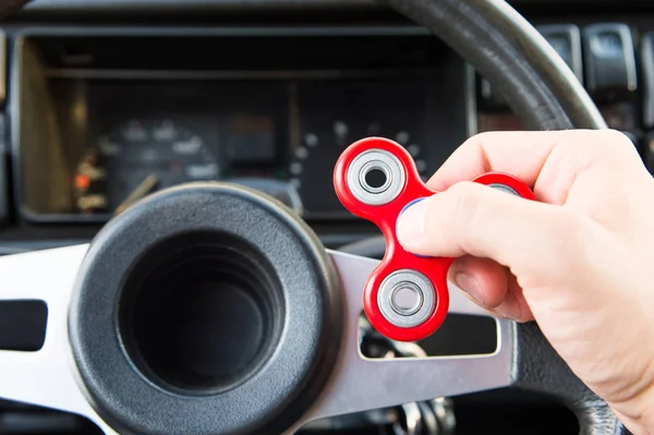 Close-up van een mans hand spelen met een spinner terwijl in een verkeersopstopping op de achtergrond van het interieur van de auto's — Stockfoto