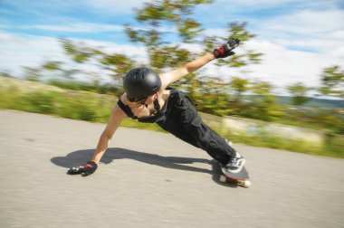 Kask içinde genç adam slayt, sparks ile bir longboard asfalt üzerinde slayt gidiyor
