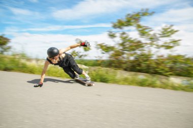 Kask içinde genç adam slayt, sparks ile bir longboard asfalt üzerinde slayt gidiyor