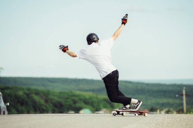 Genç bir adam karmaşık bir numara longboard üzerinde gerçekleştirir.