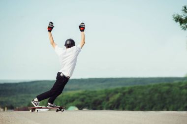 Genç bir adam karmaşık bir numara longboard üzerinde gerçekleştirir.