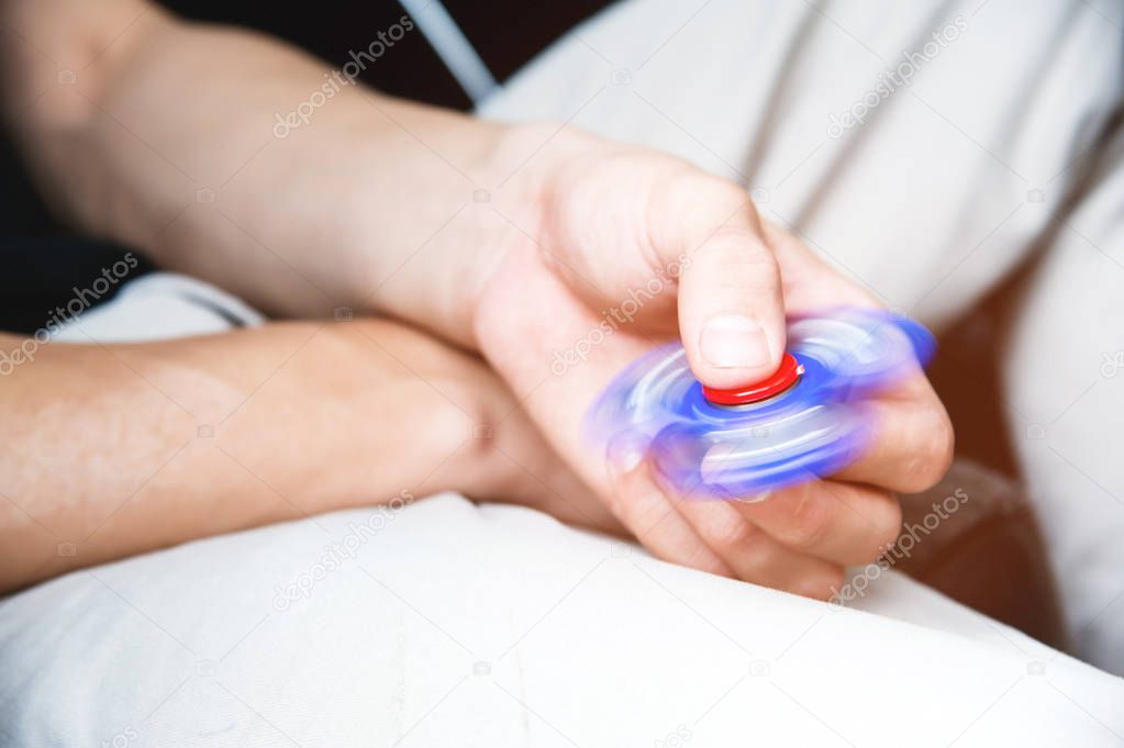 The hand plays with a spinner fidgeting hand toy