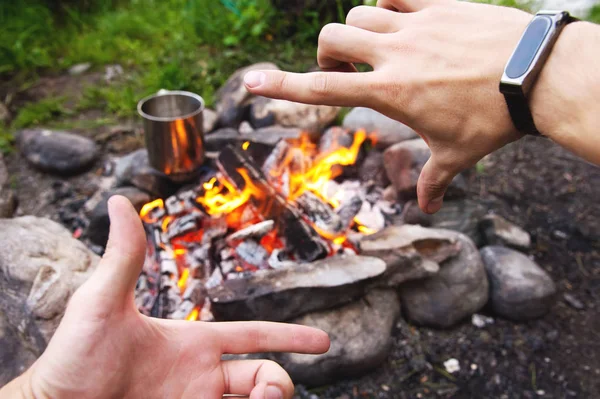 Mens hands are warming around the fire — Stock Photo, Image