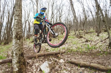 Dağ bisikleti rider bir sıçrama tahtası bir sisli ormanında, Kafkas Dağları üzerinden atlar