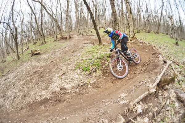 El jinete en el casco de cara completa pasa una contrarrotación en el deslizamiento sobre el fondo de un bosque brumoso . — Foto de Stock