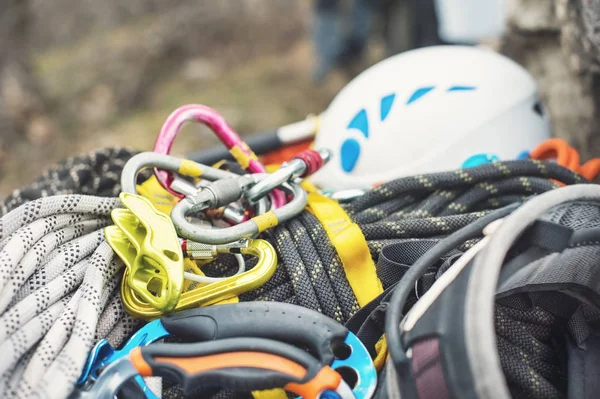 Used climbing equipment - carabiner without scratches, climbing hammer, white helmet and grey,red,green and black rope