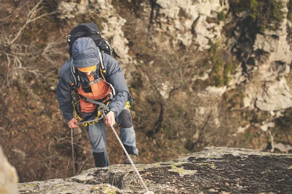 Üstten Görünüm, dağcı ipi ve kask üzerinde dikey kayanın üzerinde yükselir.