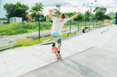 Bir çocuk bir kaykay üzerinde bir hile yaparak bir skate Park