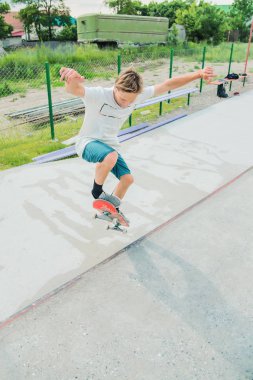Bir çocuk bir kaykay üzerinde bir hile yaparak bir skate Park