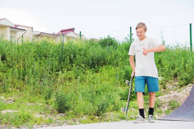 Çocuk skatepark içinde duran ve seviyor gösterilen