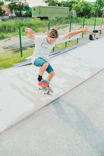 Een jongen in een skatepark doen een truc op een skateboard — Stockfoto