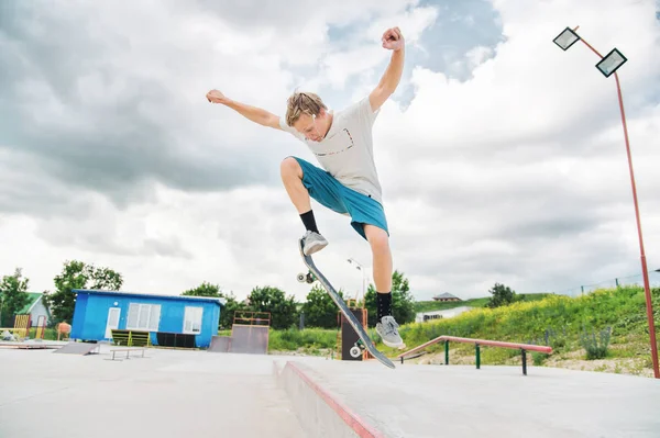 Bir çocuk bir kaykay üzerinde bir hile yaparak bir skate Park — Stok fotoğraf