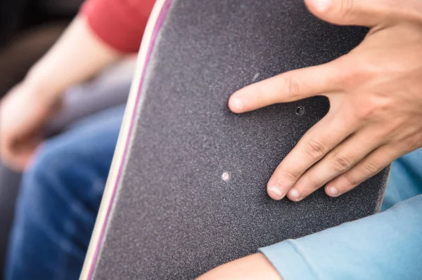 Мальчик делает болтовые отверстия на скотче на скейтборде — стоковое фото
