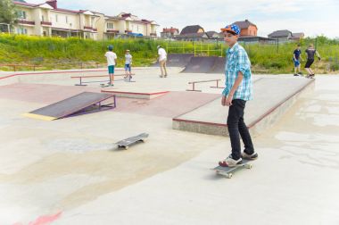 Skate park Pyatigorsk.Young Kafkas kaykaycılar açık beton skatepark sürme kaykay yarışmaya. Patenciler ödül için yarışmak... Genç kaykaycı çocuklar üzerinde paten rampası çevirmeye hazır