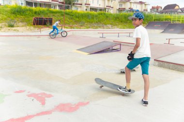 Skate park Pyatigorsk.Young Kafkas kaykaycılar açık beton skatepark sürme kaykay yarışmaya. Patenciler ödül için yarışmak... Genç kaykaycı çocuklar üzerinde paten rampası çevirmeye hazır