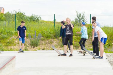 Skate park Pyatigorsk.Young Kafkas kaykaycılar açık beton skatepark sürme kaykay yarışmaya. Patenciler ödül için yarışmak... Genç kaykaycı çocuklar üzerinde paten rampası çevirmeye hazır