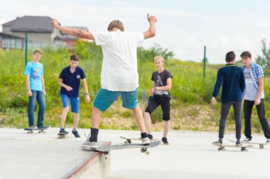 Skate park Pyatigorsk.Young Kafkas kaykaycılar açık beton skatepark sürme kaykay yarışmaya. Patenciler ödül için yarışmak... Genç kaykaycı çocuklar üzerinde paten rampası çevirmeye hazır