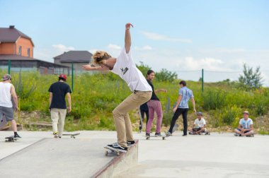 Skate park Pyatigorsk.Young Kafkas kaykaycılar açık beton skatepark sürme kaykay yarışmaya. Patenciler ödül için yarışmak... Genç kaykaycı çocuklar üzerinde paten rampası çevirmeye hazır