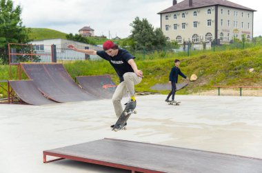 Skate park Pyatigorsk.Young Kafkas kaykaycılar açık beton skatepark sürme kaykay yarışmaya. Patenciler ödül için yarışmak... Genç kaykaycı çocuklar üzerinde paten rampası çevirmeye hazır