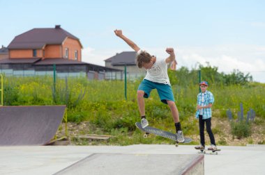 Skate park Pyatigorsk.Young Kafkas kaykaycılar açık beton skatepark sürme kaykay yarışmaya. Patenciler ödül için yarışmak... Genç kaykaycı çocuklar üzerinde paten rampası çevirmeye hazır