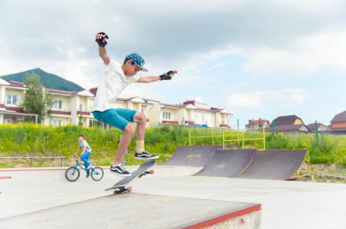 Skate park Pyatigorsk.Young Kafkas kaykaycılar açık beton skatepark sürme kaykay yarışmaya. Patenciler ödül için yarışmak... Genç kaykaycı çocuklar üzerinde paten rampası çevirmeye hazır
