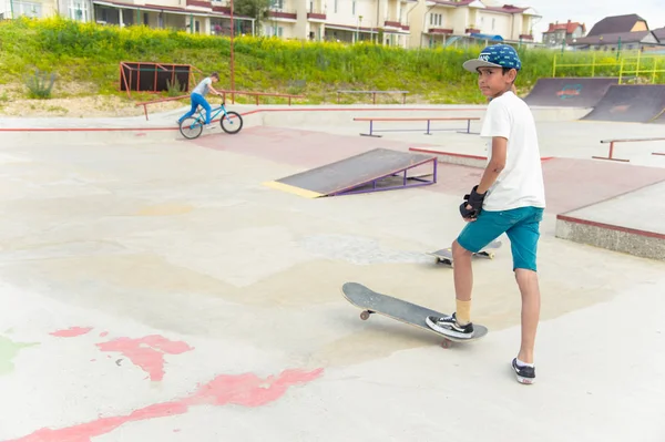 Skate park Pyatigorsk.Young Kafkas kaykaycılar açık beton skatepark sürme kaykay yarışmaya. Patenciler ödül için yarışmak... Genç kaykaycı çocuklar üzerinde paten rampası çevirmeye hazır
