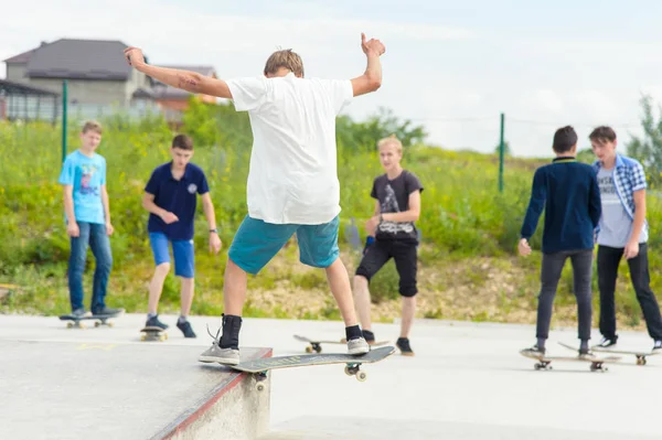 Concurso de skate no parque de skate de Pyatigorsk.Jovens skatistas caucasianos montando no skate de concreto ao ar livre.Skaters competir por prêmio.. Jovens skatistas meninos prontos para rolar na rampa de skate — Fotografia de Stock