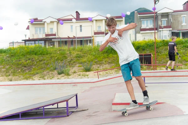 Skate park Pyatigorsk.Young Kafkas kaykaycılar açık beton skatepark sürme kaykay yarışmaya. Patenciler ödül için yarışmak... Genç kaykaycı çocuklar üzerinde paten rampası çevirmeye hazır