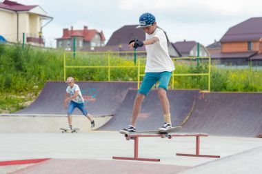 Skate park Pyatigorsk.Young Kafkas kaykaycılar açık beton skatepark sürme kaykay yarışmaya. Patenciler ödül için yarışmak... Genç kaykaycı çocuklar üzerinde paten rampası çevirmeye hazır