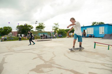 Skate park Pyatigorsk.Young Kafkas kaykaycılar açık beton skatepark sürme kaykay yarışmaya. Patenciler ödül için yarışmak... Genç kaykaycı çocuklar üzerinde paten rampası çevirmeye hazır