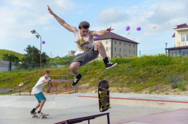 Skate park Pyatigorsk.Young Kafkas kaykaycılar açık beton skatepark sürme kaykay yarışmaya. Patenciler ödül için yarışmak... Genç kaykaycı çocuklar üzerinde paten rampası çevirmeye hazır