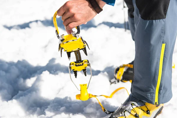 Joven caminante sostiene en su mano crampones para un paseo por el glaciar — Foto de Stock