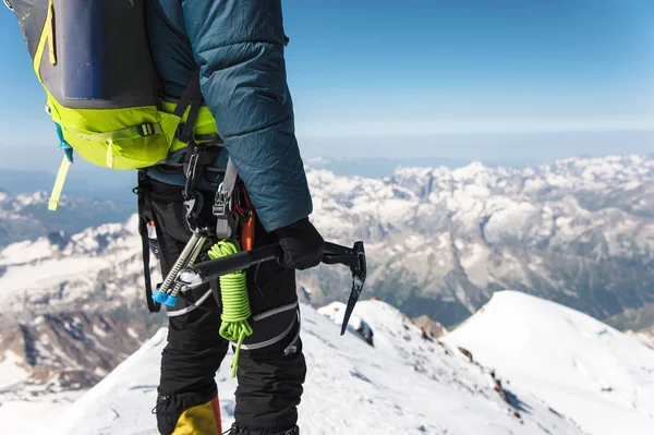 Egy fiatal srác mászó közelről tart a kezében egy jég-ax állva egy csúcs magas hegyekben. Extrém sport koncepció — Stock Fotó
