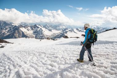 Arka planı karla kaplı dağları'nın karlı üstten yorgun gezgin iner