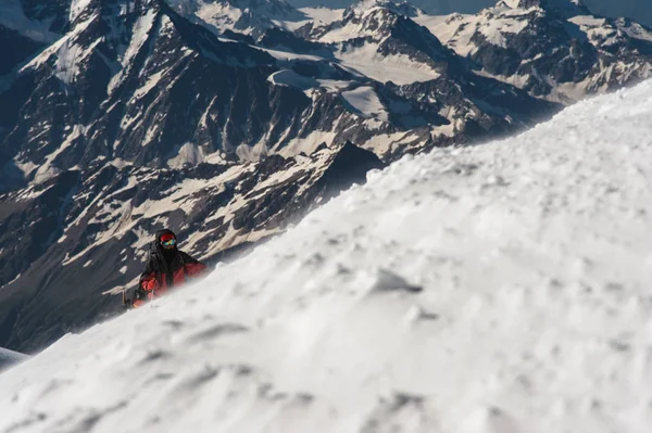 De klimmer klimt de besneeuwde top. — Stockfoto