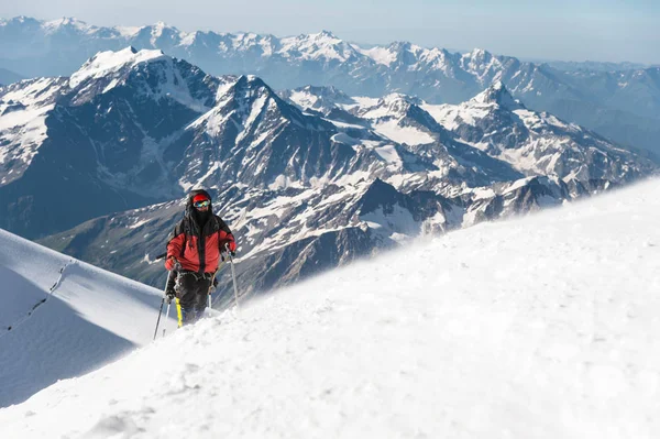 O alpinista sobe o cume coberto de neve . — Fotografia de Stock