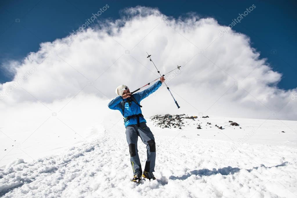 Backpacker in the mountains pretends to shoot arrows on the example of sticks for Nordic walking