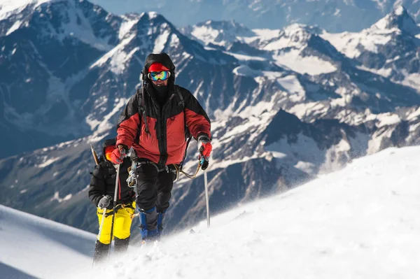 El escalador sube a la cumbre cubierta de nieve . — Foto de Stock