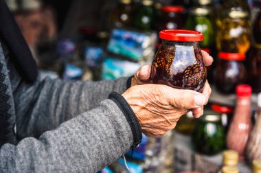 Kavanoz reçel ile kırışık yaşlı kadın el ele tutuşur