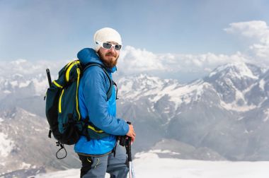 Şapka ve güneş gözlüğü takan bir sakallı rehber portresi