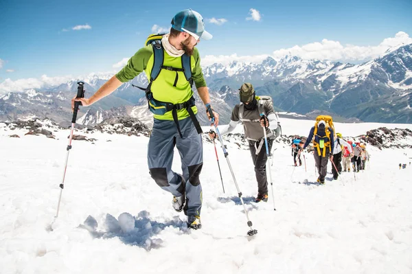 Un groupe d'alpinistes monte au sommet d'une montagne enneigée — Photo