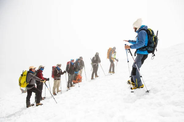 A team of climbers led by a guide discusses the upcoming ascent — Stock Photo, Image