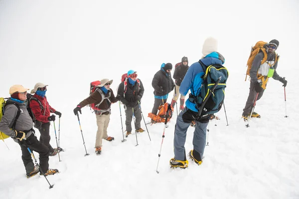 Команда альпинистов во главе с гидом обсуждает предстоящее восхождение — стоковое фото