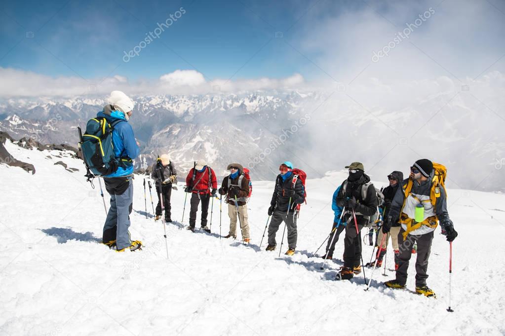 A team of climbers led by a guide discusses the upcoming ascent
