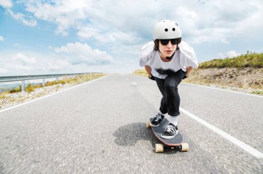 Kask içinde genç bir adam, yağmur altında yüksek hızda bir ülke yolda sürme